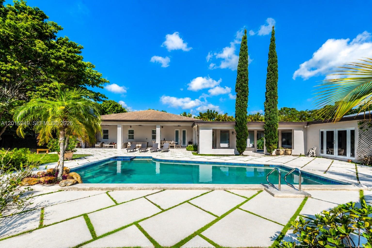 A single-story house features a large grid-patterned paver driveway and a covered front porch — 7650 SW 128th St, Pinecrest FL 33156, PINECREST, FL