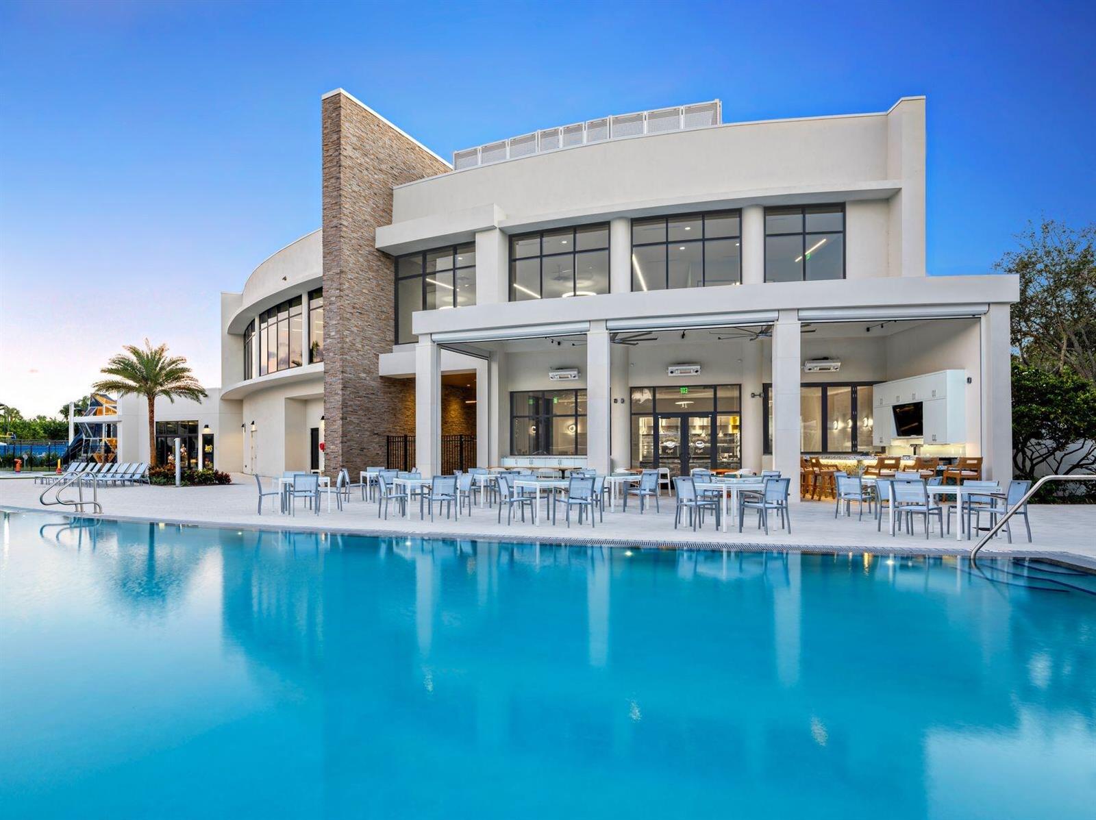 A modern two-story building with a stone accent wall sits beside a large swimming pool — 7370 Orangewood Lane # 303, Boca Raton FL 33433, BOCA RATON, FL