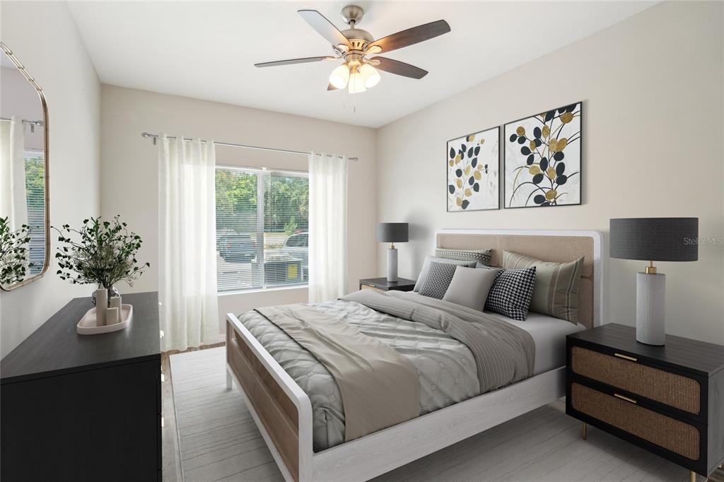 A bedroom features a bed with neutral bedding, two nightstands, and a ceiling fan — 14524 N NEBRASKA AVENUE UNIT 204A, TAMPA, FL