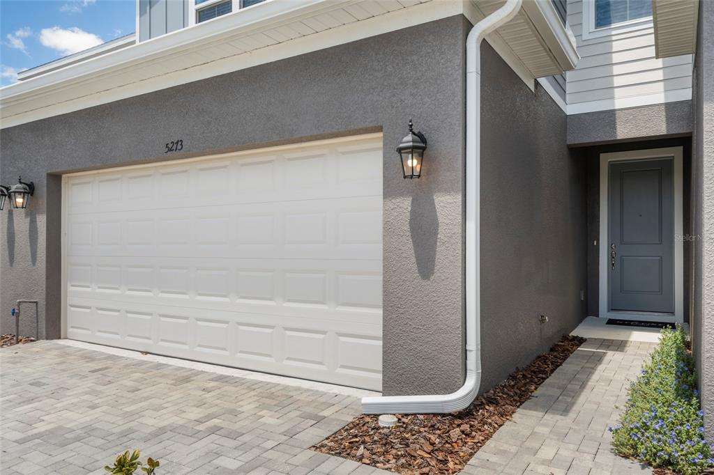 A white garage door and a gray front door are visible on this house exterior — 5273 LUISA COURT, ST CLOUD, FL