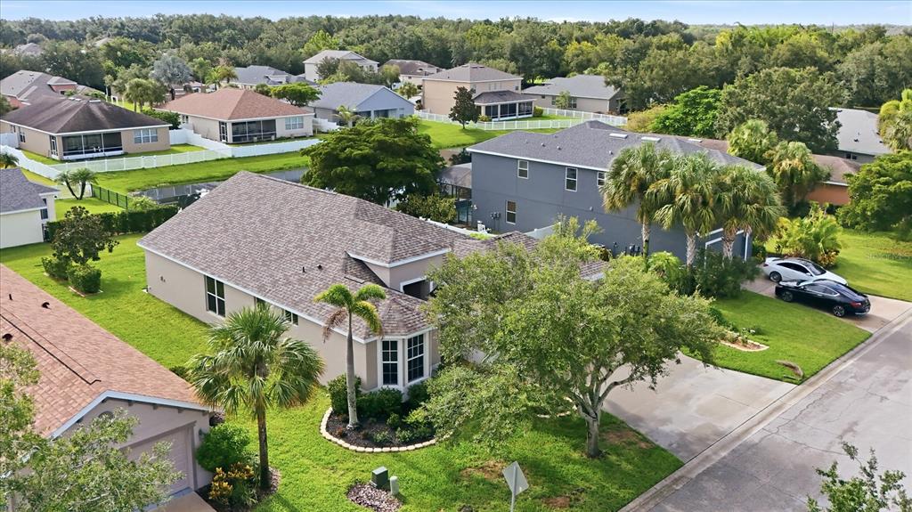 An aerial view shows suburban houses with shingled roofs, green lawns, and palm trees — 7117 50TH AVENUE CIRCLE E, PALMETTO, FL