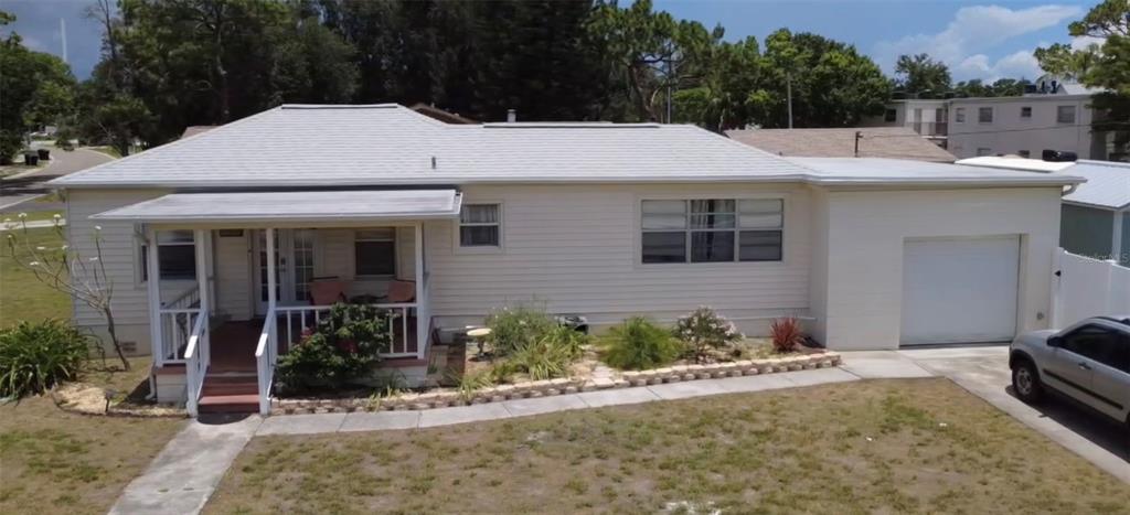 A single-story house with light siding, a front porch, and an attached garage — 146 NE MADISON CIRCLE N, ST PETERSBURG, FL
