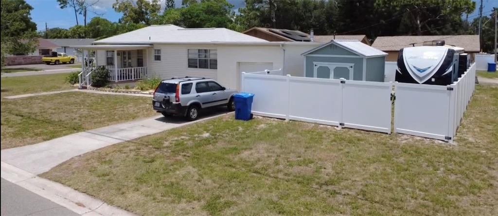 A single-story house with a white vinyl fence, a driveway, and a parked recreational vehicle — 146 NE MADISON CIRCLE N, ST PETERSBURG, FL