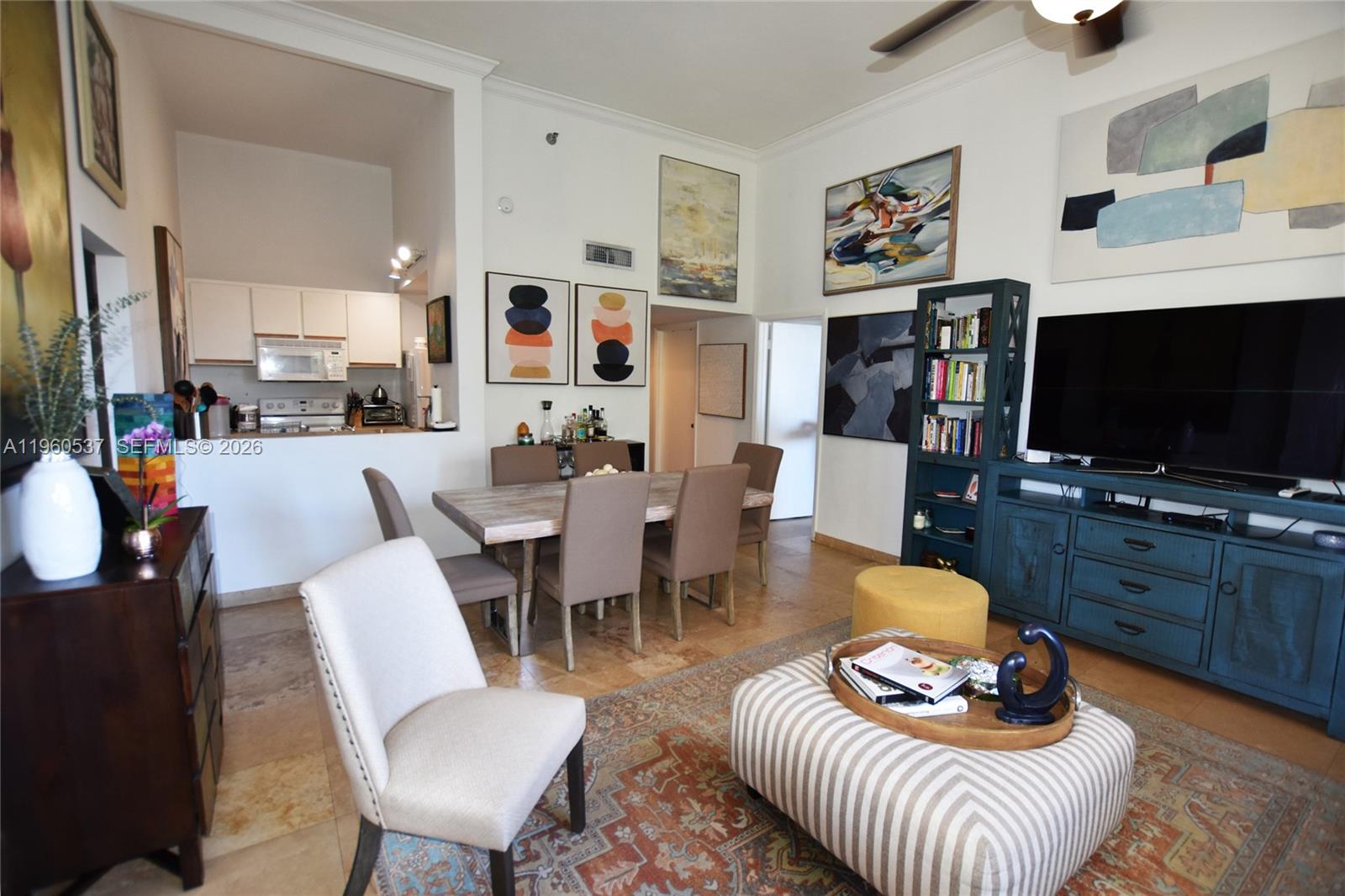 A living and dining area features tile floors, a blue media console, and wall art — 540 Brickell Key Dr # 505, Miami FL 33131, MIAMI, FL