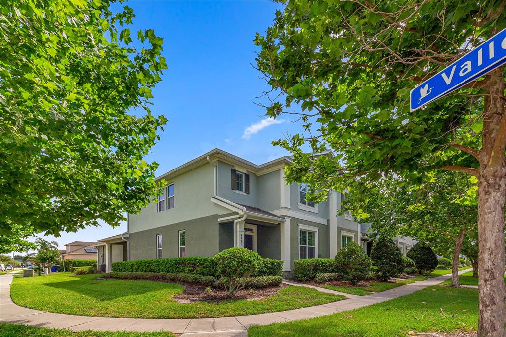 A two-story house with a green exterior and a landscaped yard on a corner lot — 4890 NATHAN HALE BOULEVARD, ST CLOUD, FL