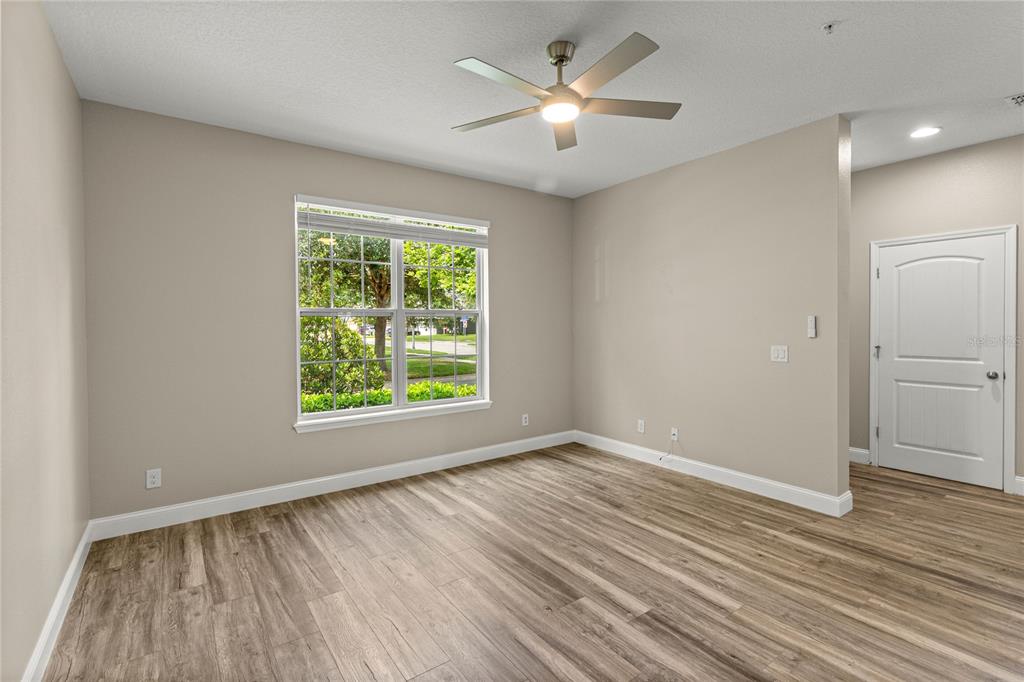 An empty bedroom features light-colored walls, wood-look flooring, a ceiling fan, and a window — 4890 NATHAN HALE BOULEVARD, ST CLOUD, FL