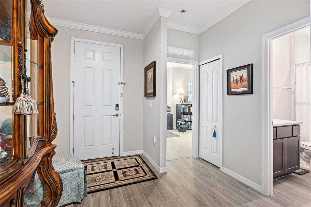 An entryway features a white door, tiled floors, a closet, and an adjacent bathroom — 1 LYONS PLACE, PALM COAST, FL
