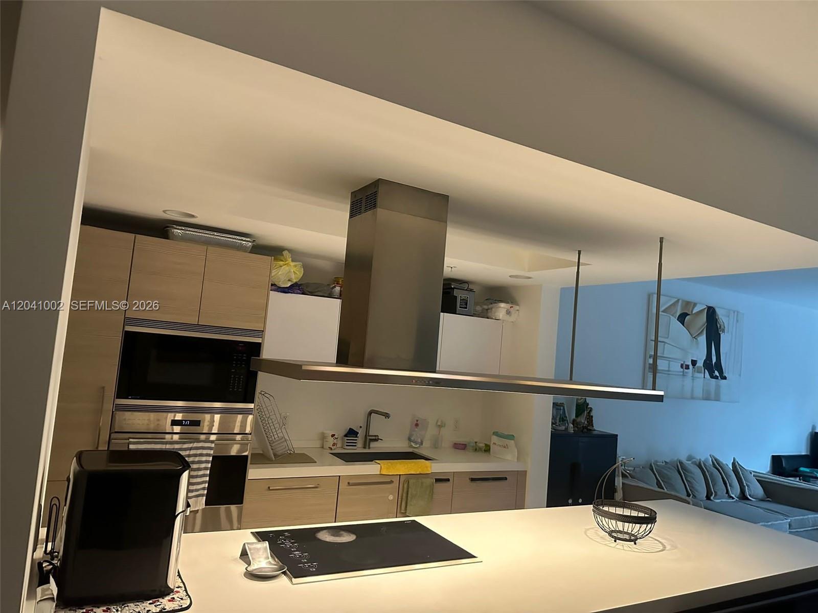 A modern kitchen features light wood cabinetry, a stainless steel range hood, and a kitchen island — 17301 Biscayne Blvd # 206, North Miami Beach FL 33160, NORTH MIAMI BEACH, FL