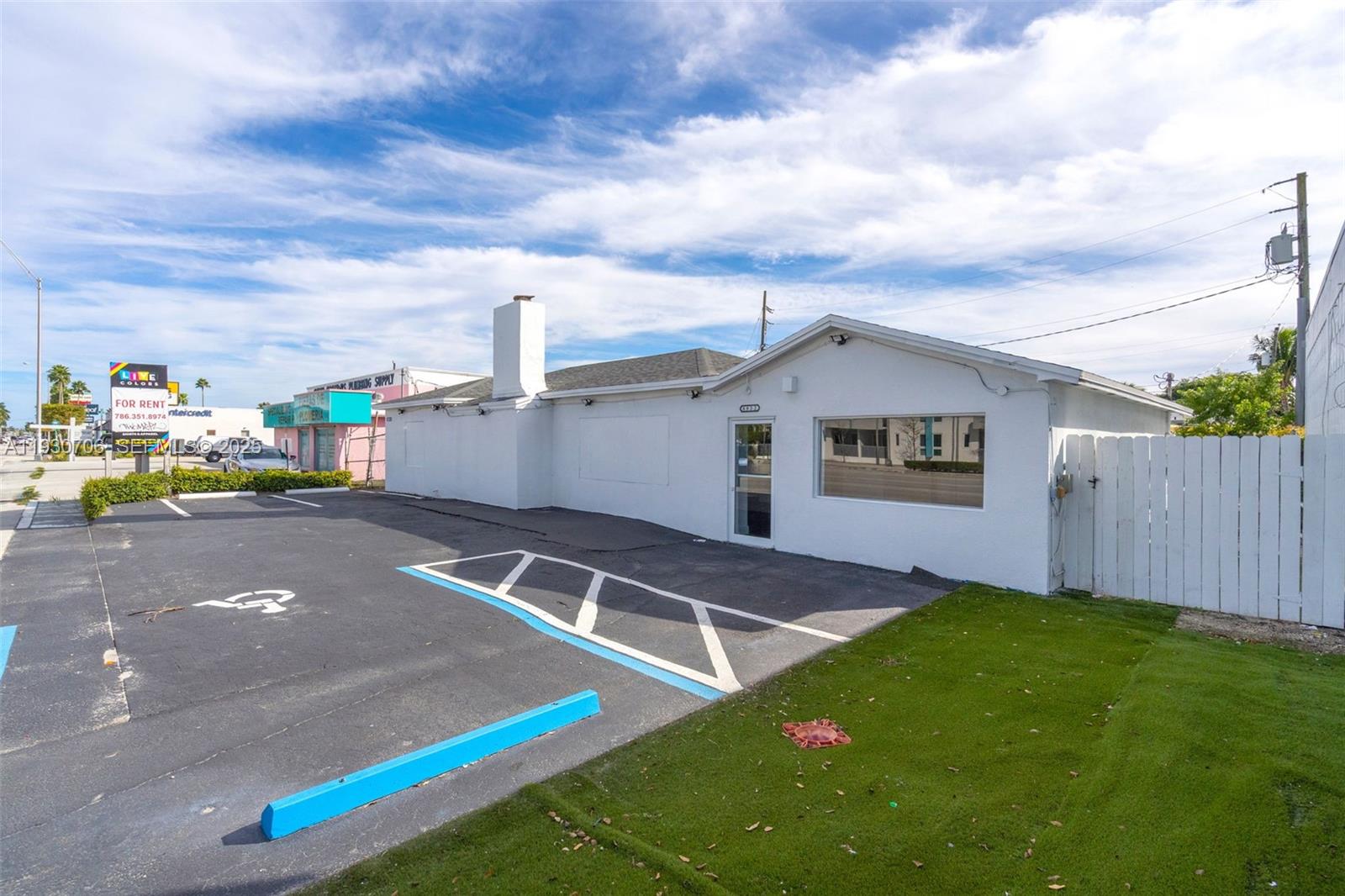 A white single-story commercial building with a parking lot and a white wooden fence — 8930 SW 40th St, Miami FL 33165, MIAMI, FL