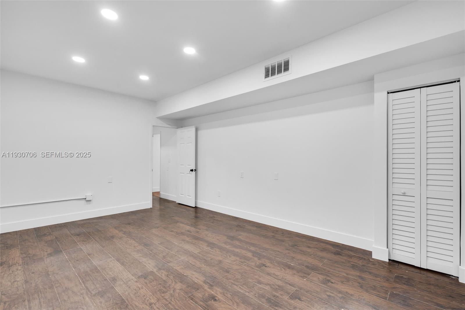 A room with white walls, recessed lighting, dark wood flooring, and a white louvered closet — 8930 SW 40th St, Miami FL 33165, MIAMI, FL