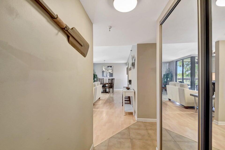 A hallway with a wooden oar on the wall leads into a living and dining area — 950 Lavers Circle # F309, Delray Beach FL 33444, DELRAY BEACH, FL