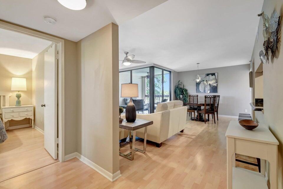 A view from a hallway into a living and dining area with light wood floors — 950 Lavers Circle # F309, Delray Beach FL 33444, DELRAY BEACH, FL