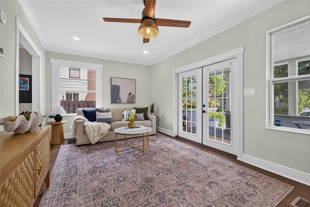 A living room features a beige sofa, a patterned rug, and glass doors leading outside — 629 6TH AVENUE N, ST PETERSBURG, FL