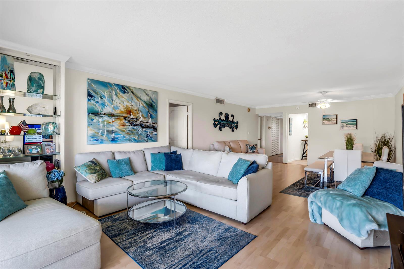 A living room features a white sectional sofa, a glass coffee table, and blue accents — 2871 N Ocean Boulevard # C307, Boca Raton FL 33431, BOCA RATON, FL
