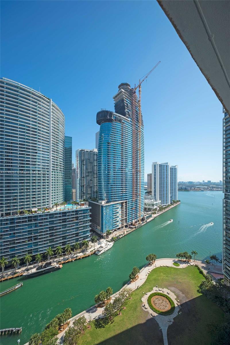A dining area features a glass table, four tan chairs, a large mirror, and hardwood floors — 485 Brickell Ave # 2603, Miami FL 33131, MIAMI, FL