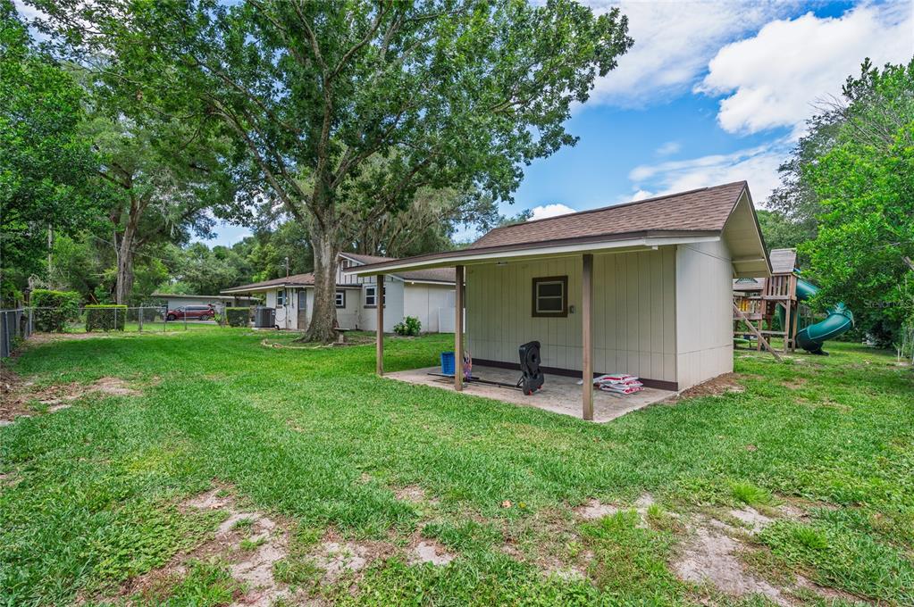 A kitchen features white cabinets, stainless steel appliances, a tile backsplash, and light wood flooring — 405 OAKHURST STREET, ALTAMONTE SPRINGS, FL