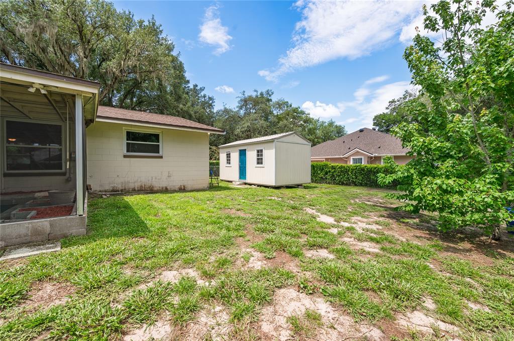 A kitchen features white cabinets, stainless steel appliances, a mosaic backsplash, and light wood flooring — 405 OAKHURST STREET, ALTAMONTE SPRINGS, FL