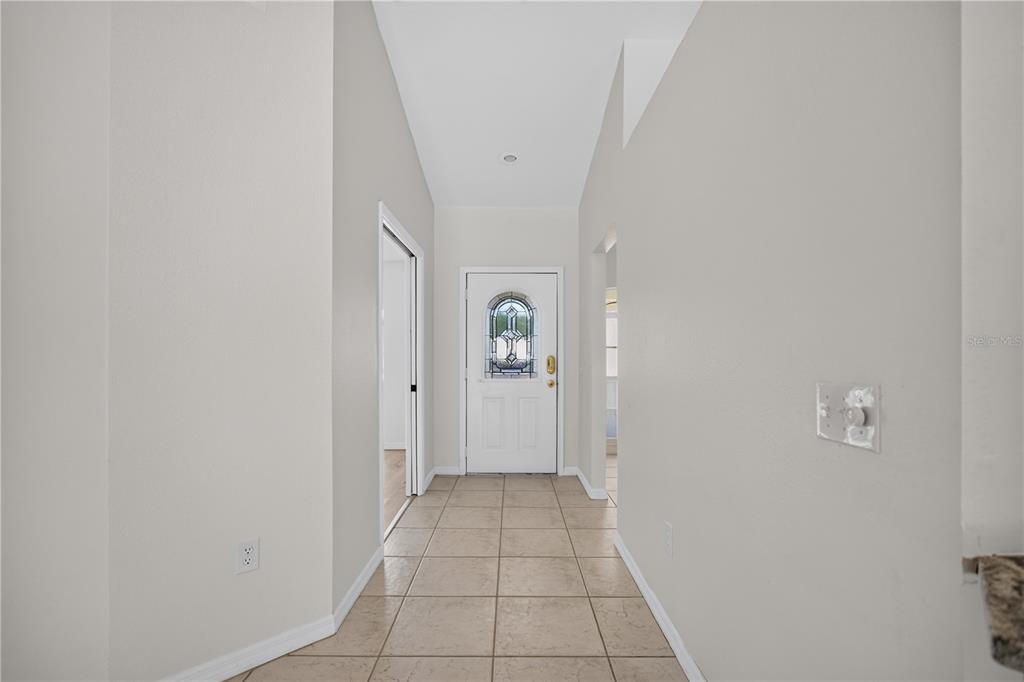 A tiled entryway features a white front door with a decorative glass insert — 6035 HILLSIDE HEIGHTS DRIVE, LAKELAND, FL
