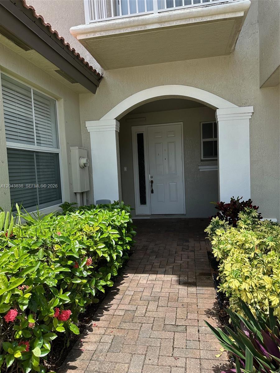 A brick walkway leads to a white front door framed by an arched entryway — 15305 SW 89th Ter # 0, Miami FL 33196, MIAMI, FL