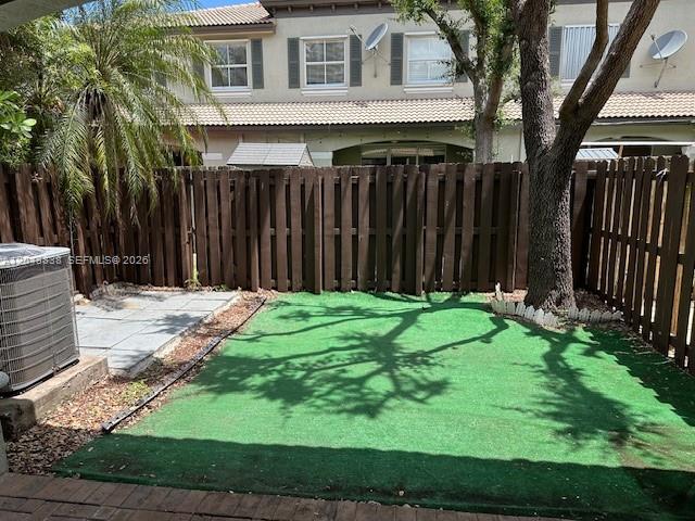 A small backyard features a patch of artificial turf, a privacy fence, and an AC unit — 15305 SW 89th Ter # 0, Miami FL 33196, MIAMI, FL
