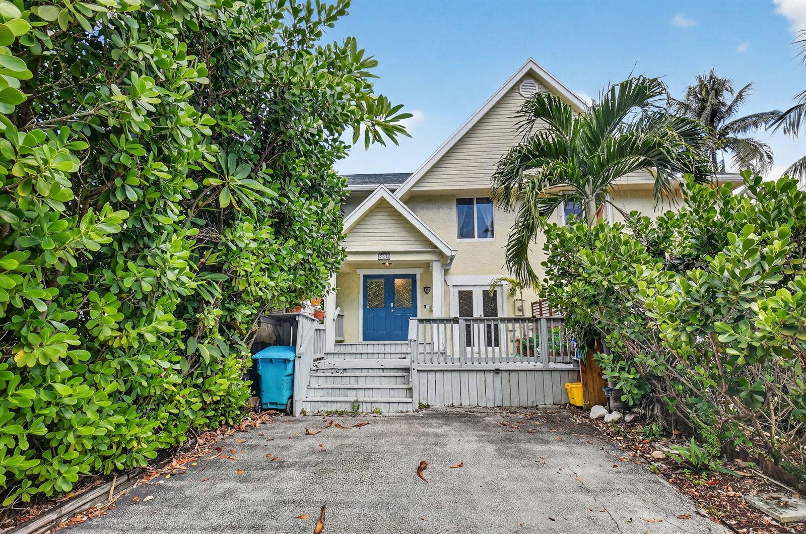 A two-story house with a blue front door, wooden deck, and driveway surrounded by trees — 732 Rider Road, Boynton Beach FL 33435, BOYNTON BEACH, FL