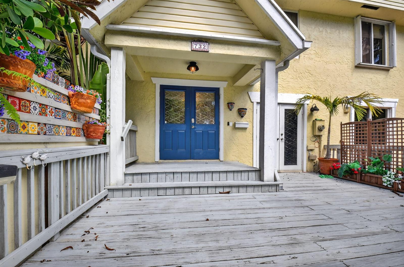 A wooden deck leads to a house entrance with blue double doors and a porch — 732 Rider Road, Boynton Beach FL 33435, BOYNTON BEACH, FL