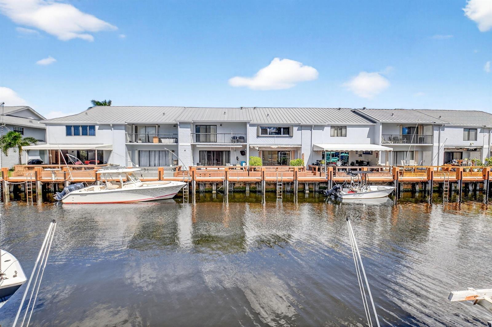 A multi-unit waterfront building with private docks and boats moored along a canal — 732 Rider Road, Boynton Beach FL 33435, BOYNTON BEACH, FL