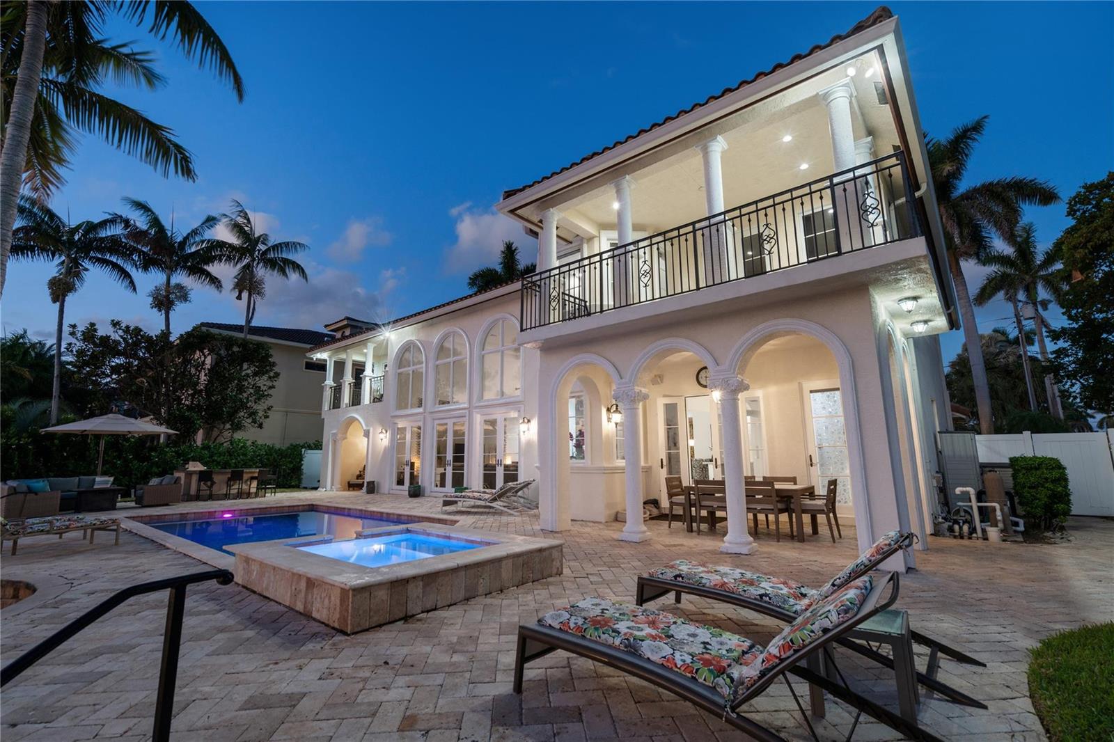 A two-story house with a pool, hot tub, and covered patio at twilight — 2833 NE 32nd Street, Lighthouse Point FL 33064, LIGHTHOUSE POINT, FL