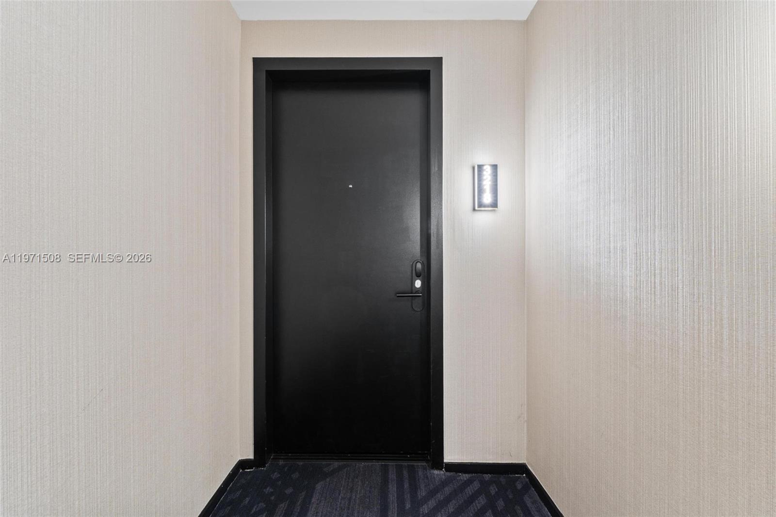A black door with a lit unit number sign is set between two textured walls — 398 NE 5th St # 3218, Miami FL 33132, MIAMI, FL