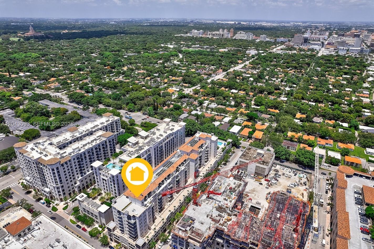 An aerial view shows a multi-story apartment complex next to a large construction site — 4100 Salzedo St # 502, Coral Gables FL 33146, CORAL GABLES, FL