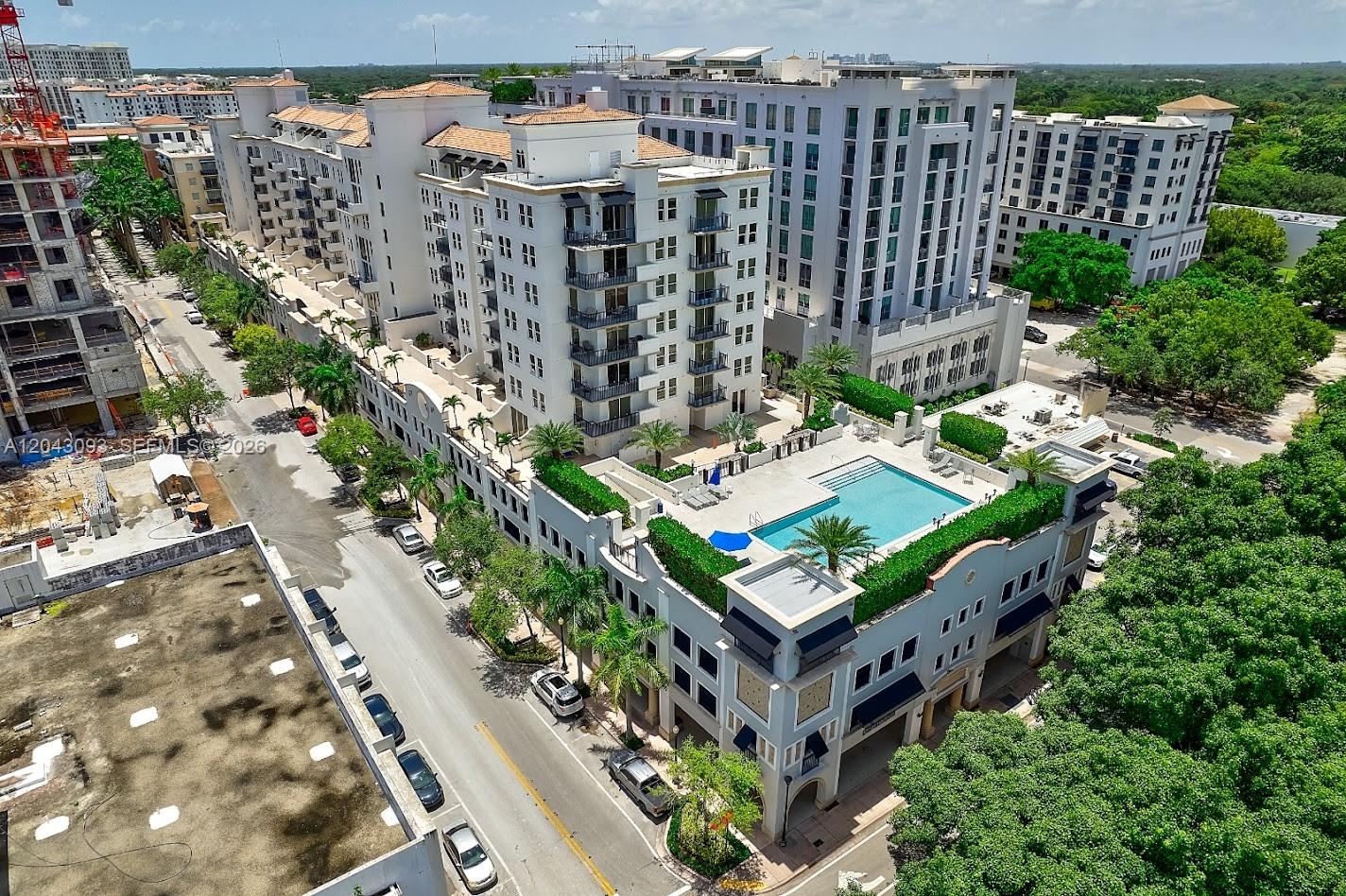 An aerial view shows a multi-story apartment complex with a rooftop pool and surrounding streets — 4100 Salzedo St # 502, Coral Gables FL 33146, CORAL GABLES, FL