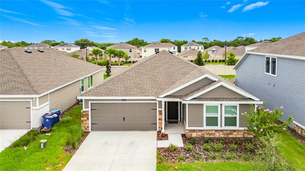 An exterior view of a single-story suburban house with a two-car garage and driveway — 2526 AVEENO AVENUE, HAINES CITY, FL
