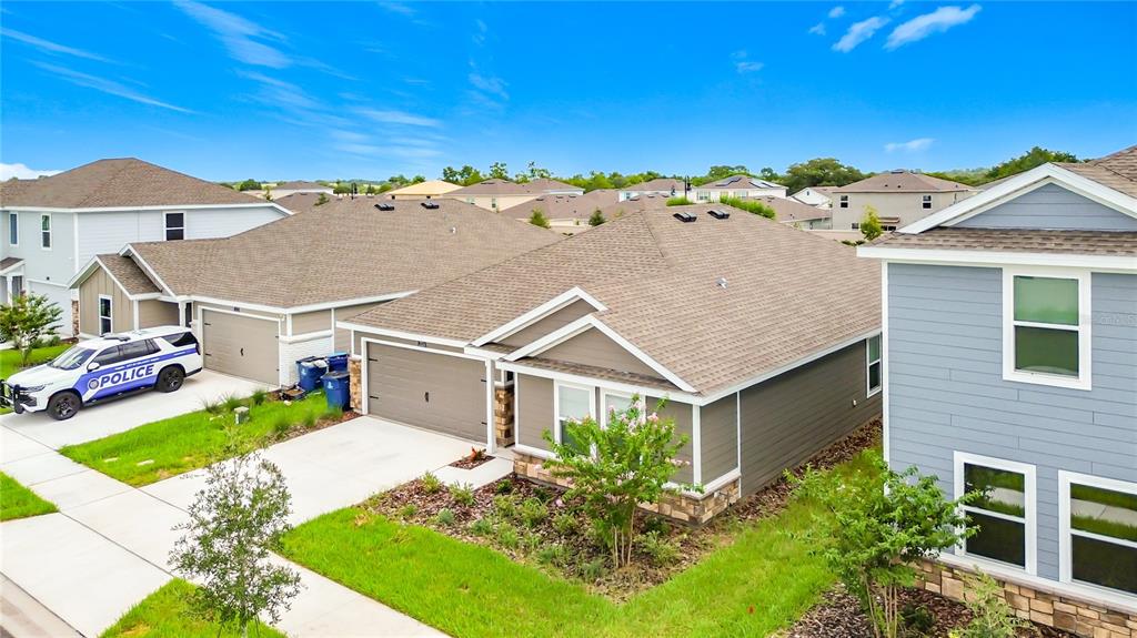 A suburban street view shows several single-family homes with a police vehicle parked nearby — 2526 AVEENO AVENUE, HAINES CITY, FL