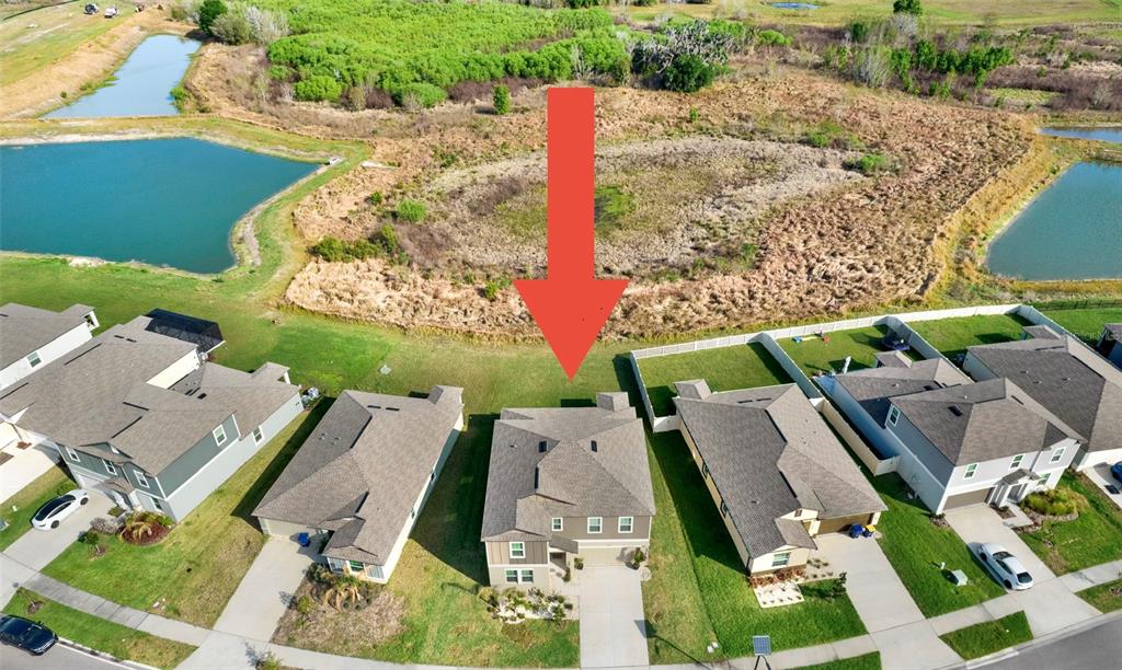 An aerial view shows a suburban house with a red arrow pointing toward its backyard — 11307 LINDEN DEPOT ROAD, SAN ANTONIO, FL