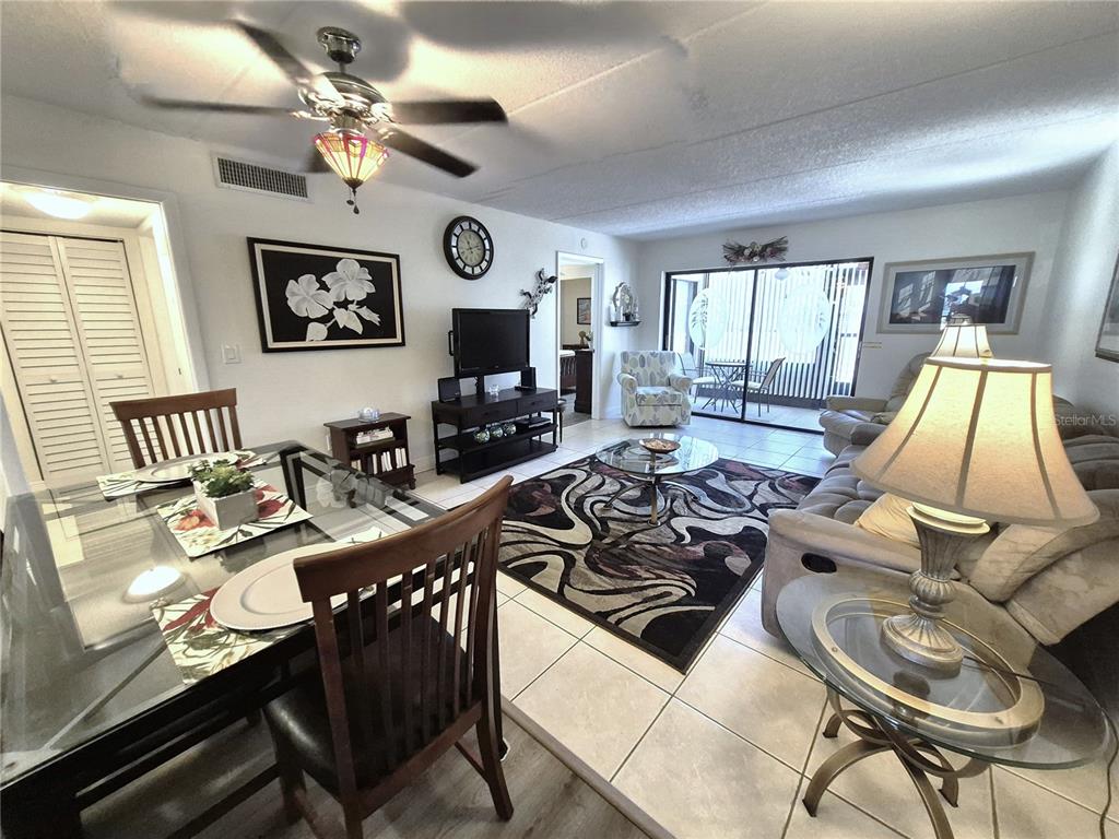A living and dining room area features tile flooring, a ceiling fan, and sliding glass doors — 107 WINDWARD PLACE UNIT 107, OLDSMAR, FL