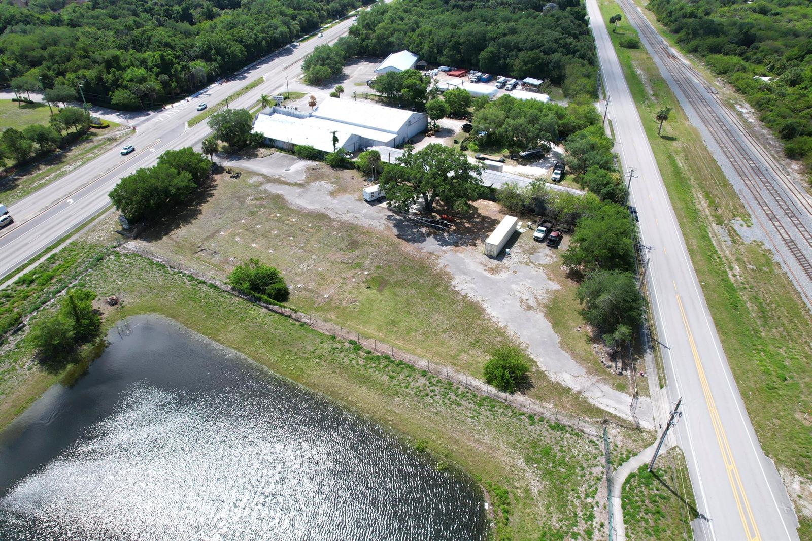 An aerial view shows a commercial property with a warehouse, parking area, and pond — 5145 Us Highway 1 Highway, Vero Beach FL 32967, VERO BEACH, FL