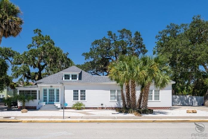 A white, single-story house with a hip roof and a palm tree in the front yard — 301 LIVE OAK STREET, NEW SMYRNA BEACH, FL