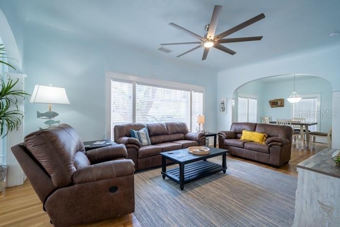 A living room features light blue walls, brown leather furniture, and a large ceiling fan — 301 LIVE OAK STREET, NEW SMYRNA BEACH, FL