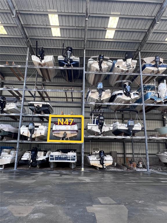 A large indoor boat storage facility features multiple levels of stacked boats on metal racks — 100 CIRCUIT ROAD UNIT #N-47, NOKOMIS, FL