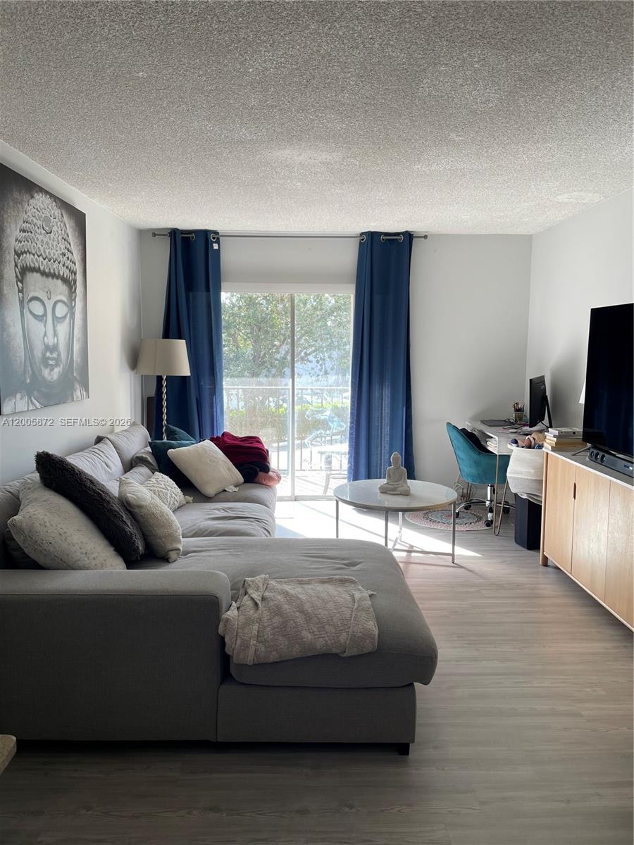 A living room features a grey sectional sofa, a coffee table, and a desk area — 8500 SW 109th Ave # 229, Miami FL 33173, MIAMI, FL