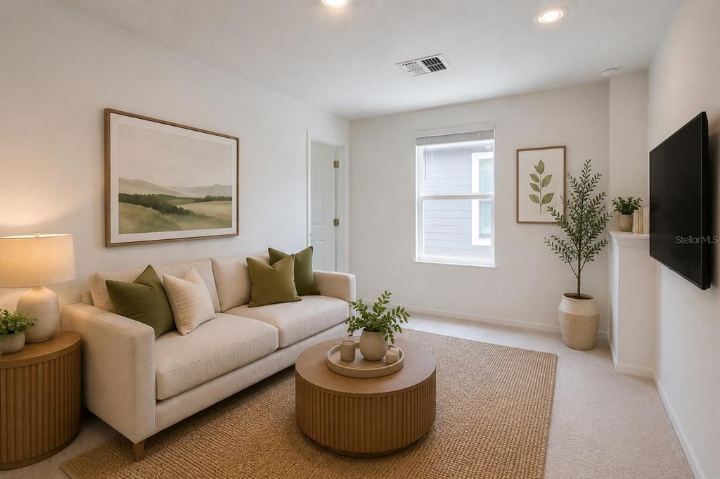 A living room features a beige sofa, round coffee table, and wall-mounted television — 17534 SHIREWOOD WAY, LAND O LAKES, FL