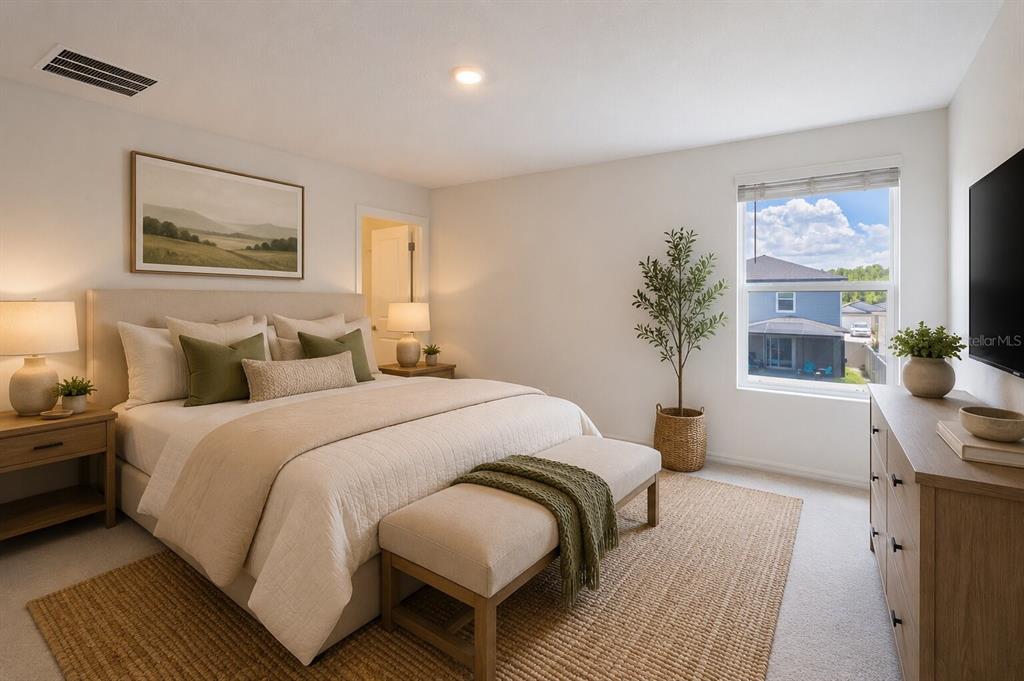 A bedroom features a bed with neutral bedding, a wooden dresser, and a window view — 17534 SHIREWOOD WAY, LAND O LAKES, FL