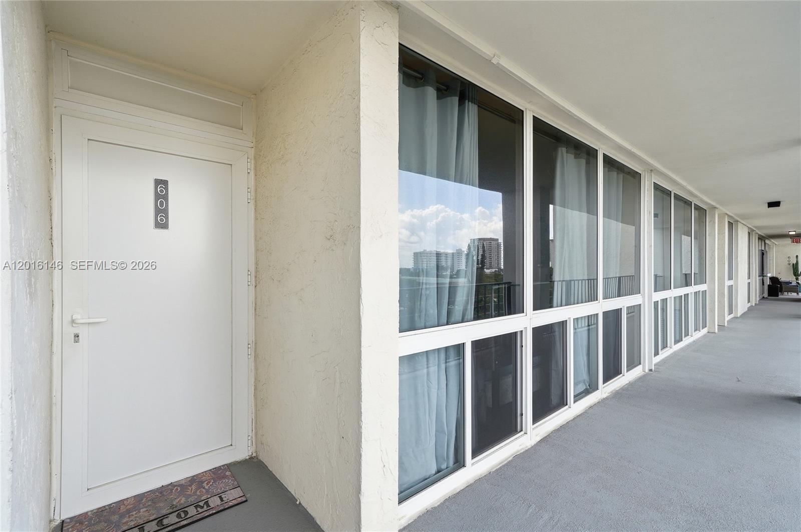 A white door labeled 606 sits next to a long wall of windows on a balcony — 521 N Riverside Dr # 606, Pompano Beach FL 33062, POMPANO BEACH, FL