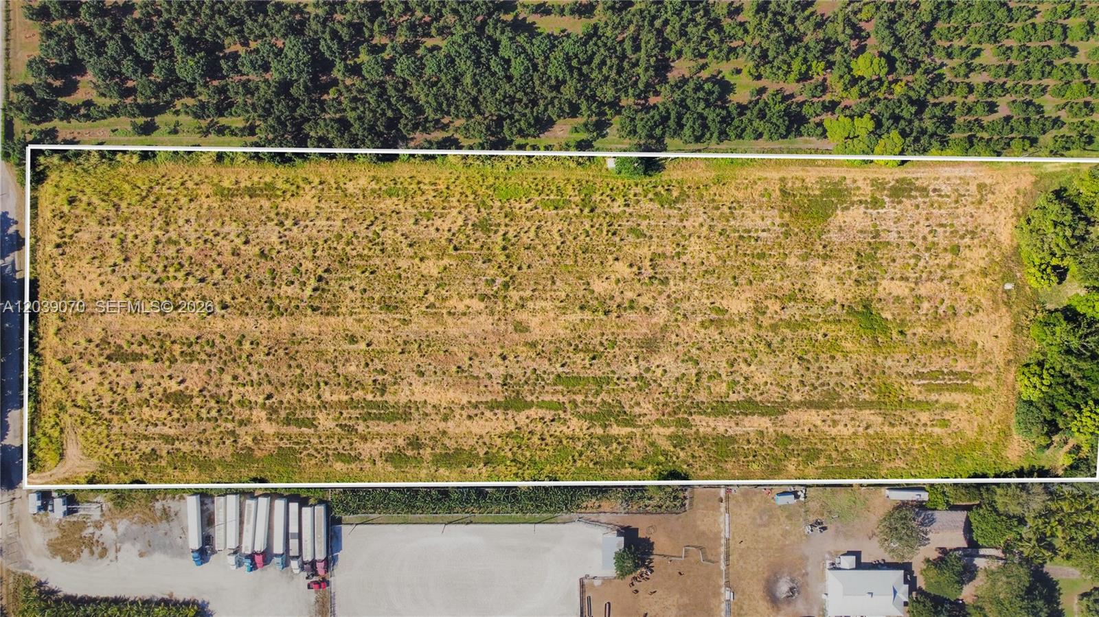 An aerial view shows a rectangular, undeveloped grassy lot bordered by trees and adjacent properties — 14350 SW 232nd St, Miami FL 33170, MIAMI, FL