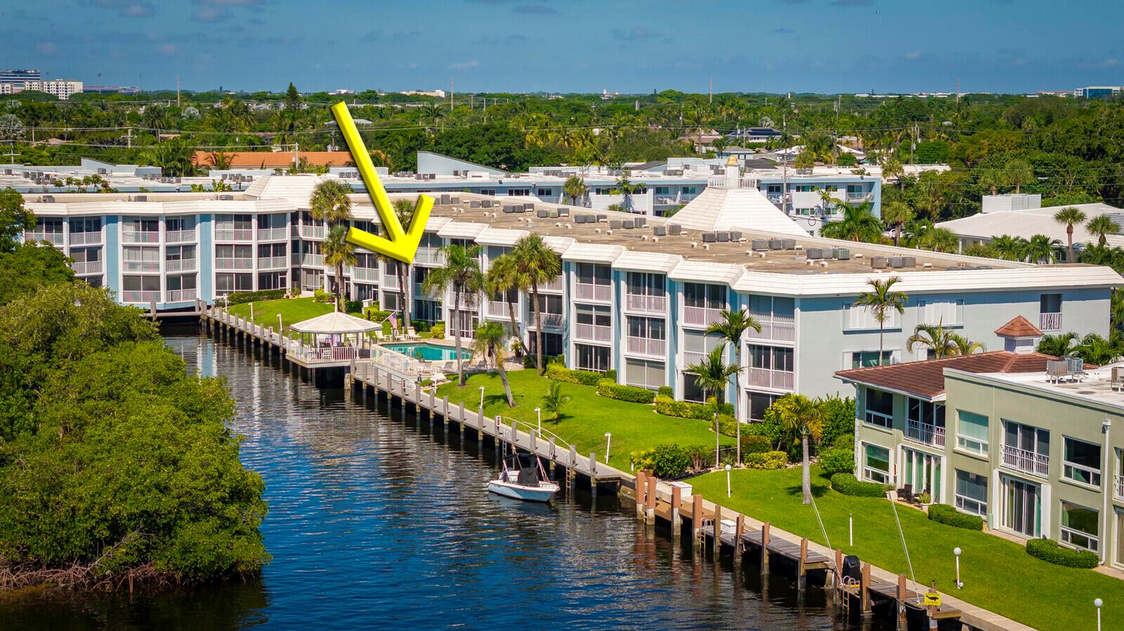 An aerial view of a multi-story apartment building with a waterfront pool and boat dock — 700 NE Harbour Terrace # 2310, Boca Raton FL 33431, BOCA RATON, FL