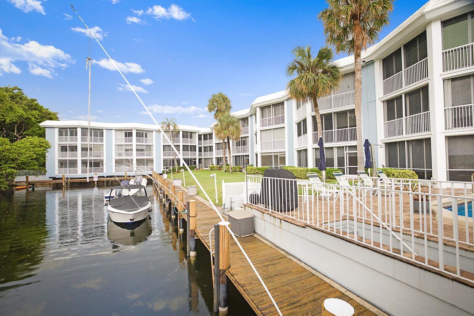 A sunroom with tile floors, a dining set, and sliding glass doors overlooking a canal — 700 NE Harbour Terrace # 2310, Boca Raton FL 33431, BOCA RATON, FL