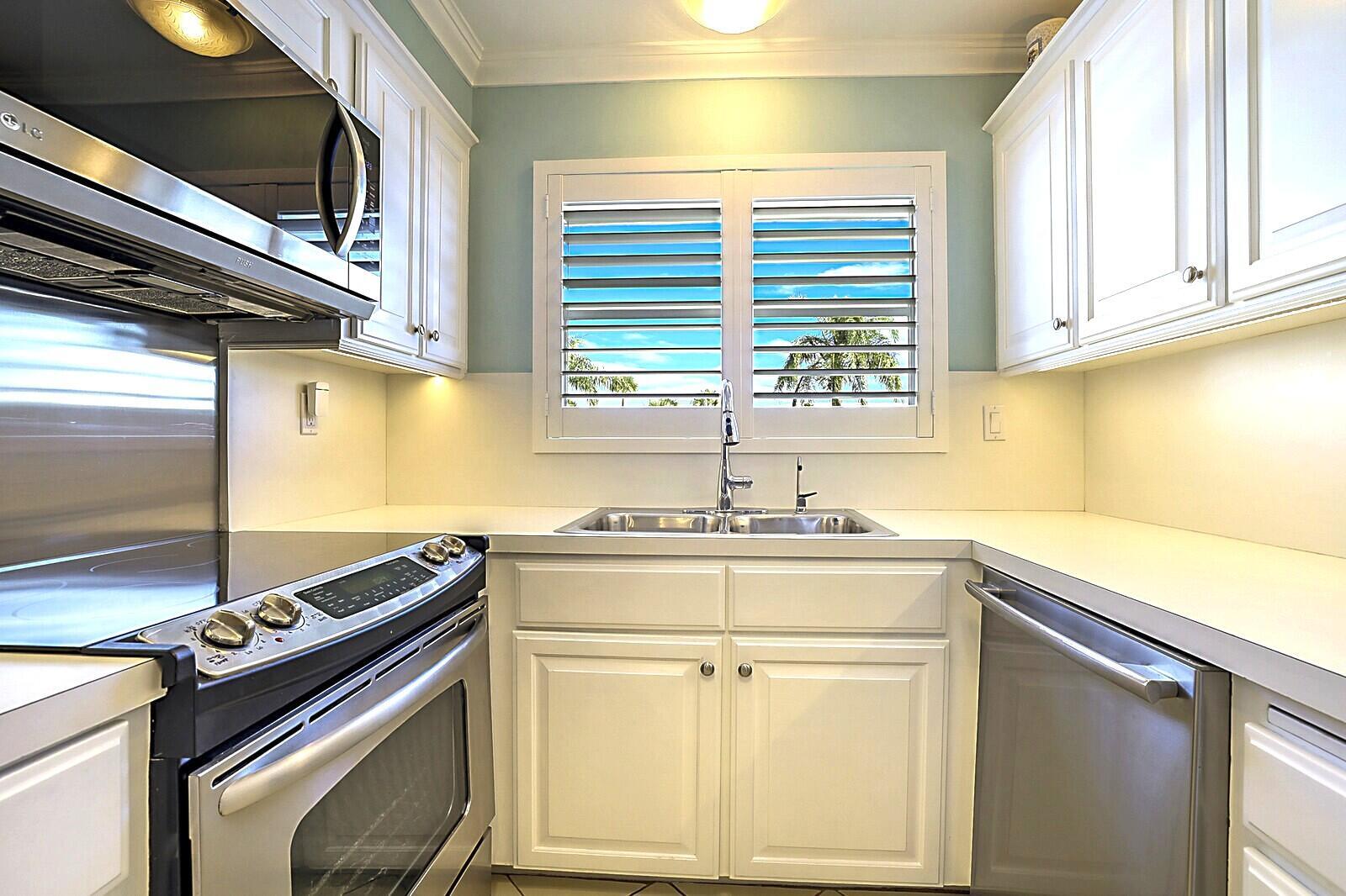 A sunroom with tile floors, a dining set, and a recliner overlooking a canal view — 700 NE Harbour Terrace # 2310, Boca Raton FL 33431, BOCA RATON, FL