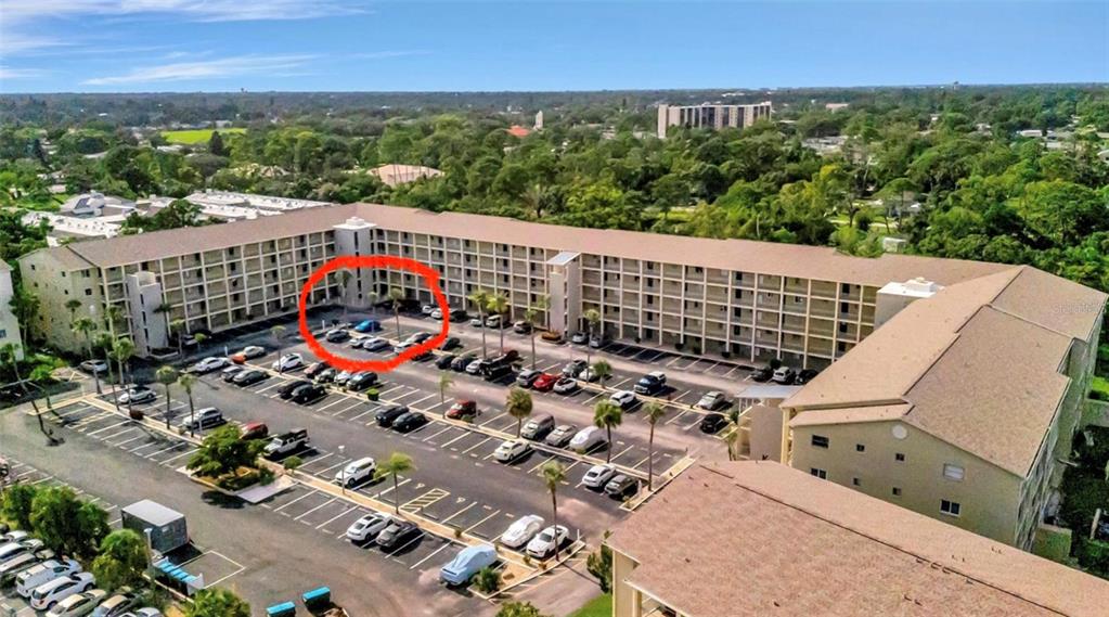 An aerial view shows a multi-story apartment building with a large parking lot — 3514 LAKE BAYSHORE DRIVE UNIT K-108, BRADENTON, FL