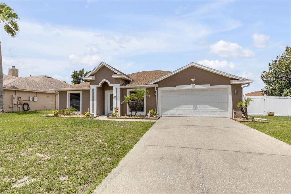 A single-story house with a brown exterior, white trim, and a two-car garage — 1510 BRAYTON CIRCLE, DELTONA, FL