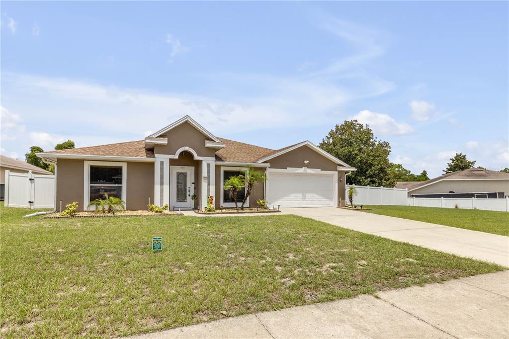 A single-story house with a brown exterior, a two-car garage, and a white front door — 1510 BRAYTON CIRCLE, DELTONA, FL